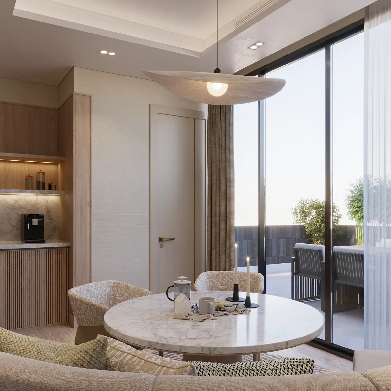 Contemporary interior design in a breakfast nook with a marble table, textured fabric chairs, and a wooden kitchenette, accented by a modern pendant light and floor-to-ceiling windows that offer natural light and a view of the terrace.